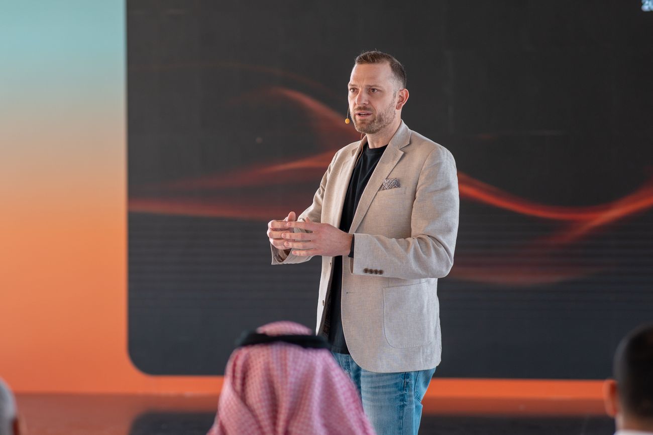 Alex Collins presenting at a town hall in Saudi Arabia